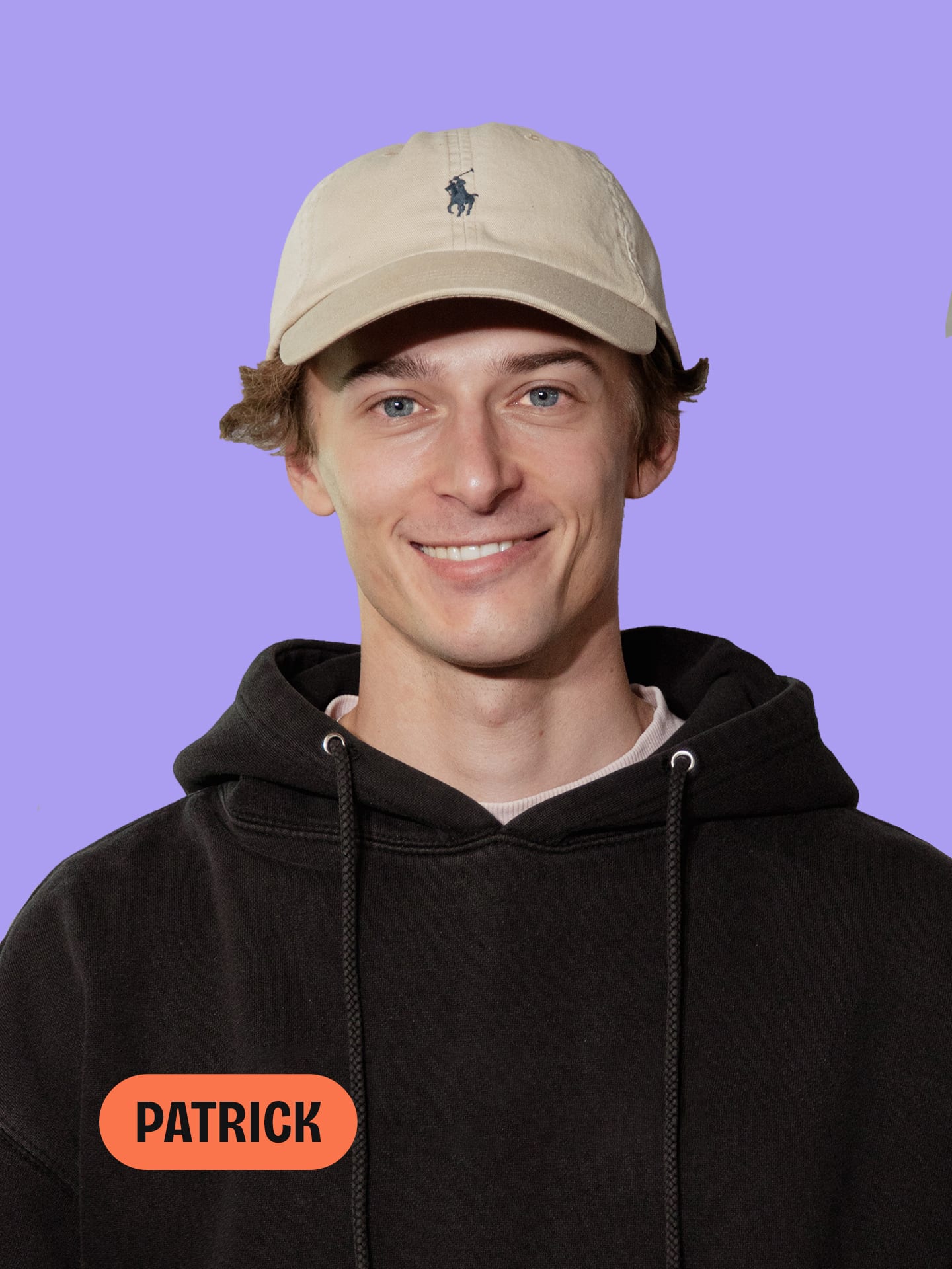 Ein lächelnder junger Mann namens Patrick trägt ein beiges Cap und einen schwarzen Hoodie vor lila Hintergrund.